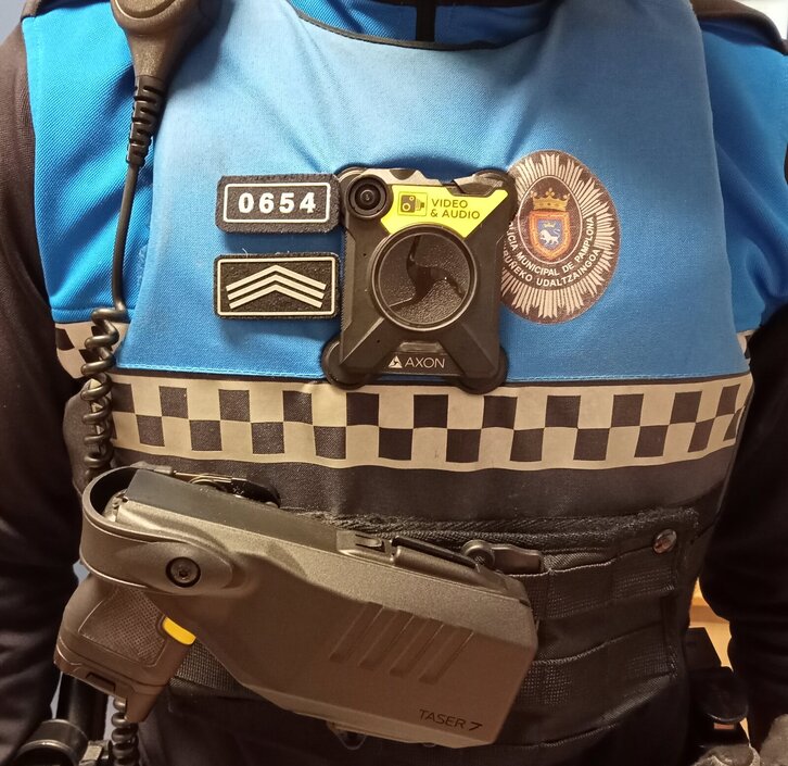 Agente con una cámara en el pecho y la Taser enfundada.