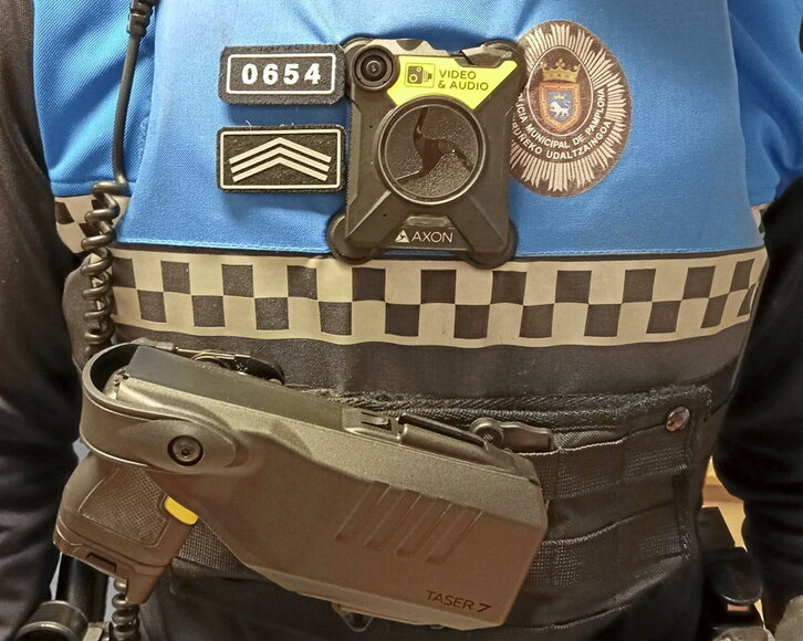 Agente con una cámara en el pecho y la Taser enfundada.