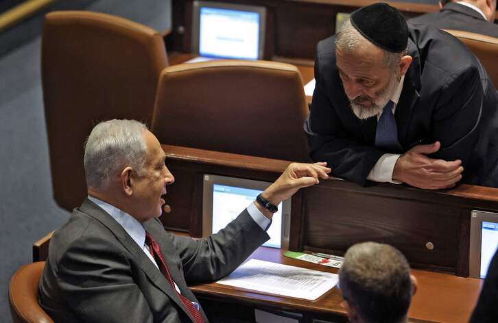 Benjamin Netanyahu charla en la Knesset con Aryeh Deri, del partido ultraortodoxo Shas.