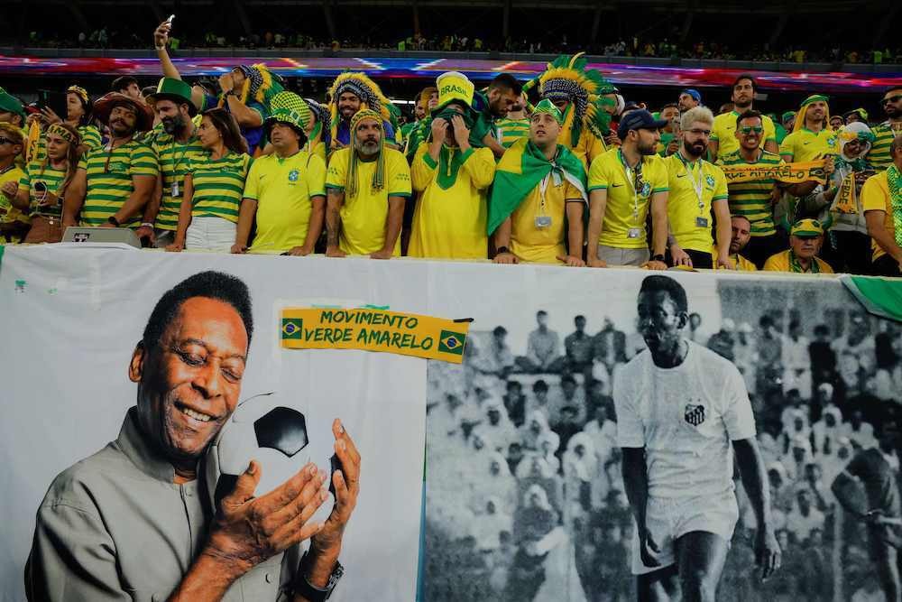 Aficionados brasile&ntilde;os en el Mundial con una pancarta de Pel&eacute;. (Odd ANDERSEN / AFP)