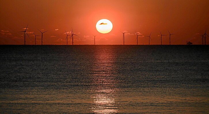 Egunsentia, Saint-Nazaire (Estatu frantsesa) hiritik gertu dagoen parke eolikoan. Energia iturri berriztagarrien aldeko apustua ezinbestekoa da trantsizio energetikoa arrakastaz egiteko. (Loic VENANCE / AFP)