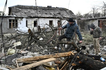 Residentes caminan entre los escombros provocados por una bomba en las afueras de Kiev.