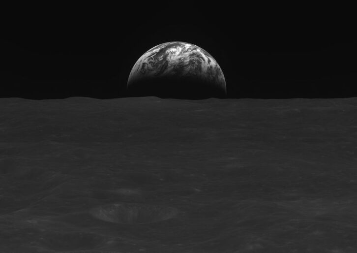 En esta foto en blanco y negro tomada el 31 de diciembre de 2022, la superficie lunar y la Tierra son visibles desde el orbitador Danuri.