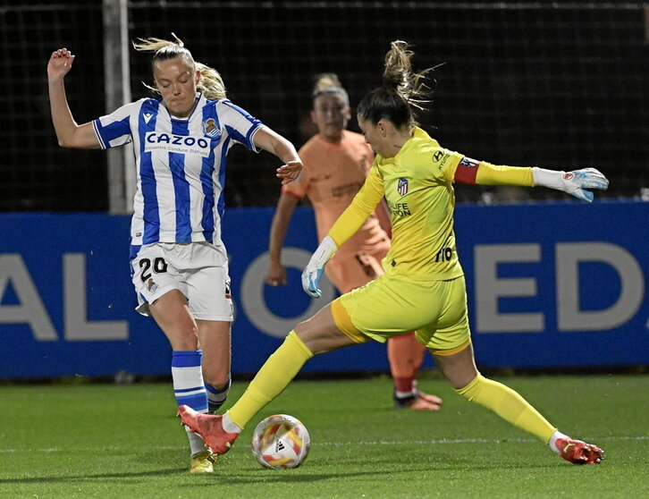 Lola Gallardo intenta despejar el balón ante la llegada de Jensen.
