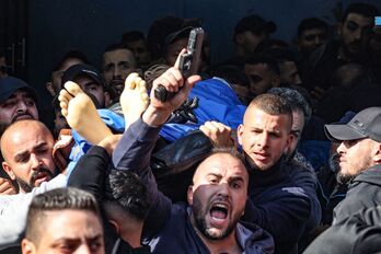 Un palestino dispara al aire su arma durante el funeral de una de las víctimas de la mortal redada israelí de Jenin.