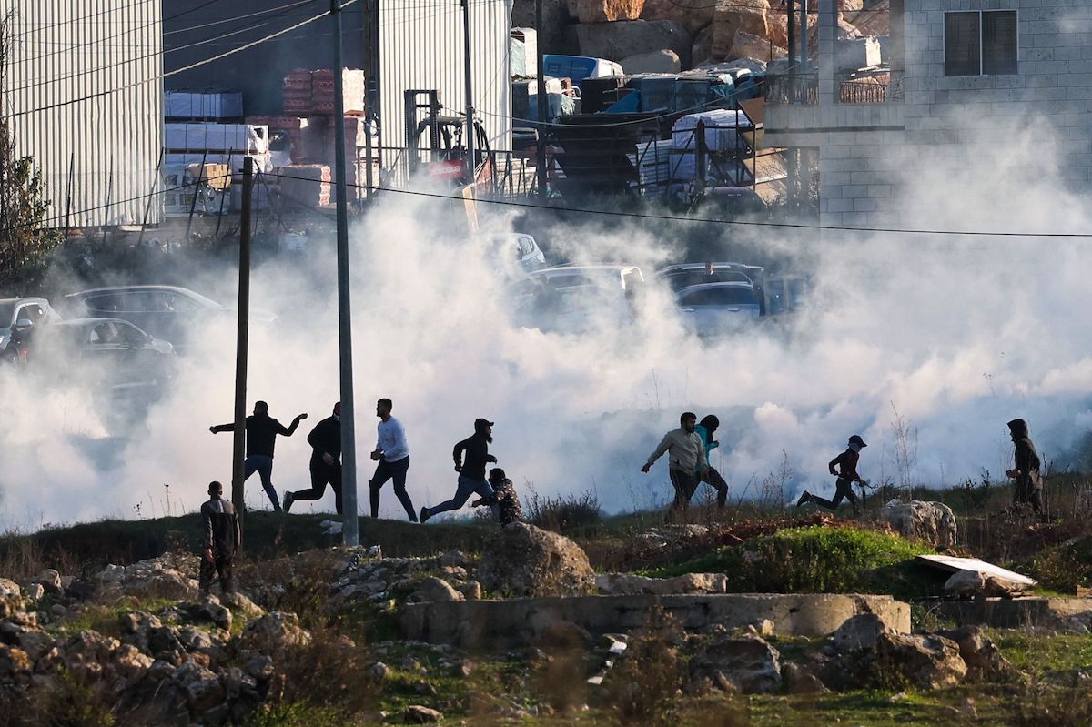 Fuerzas israelíes arrojan gases lacrimógenos para dispersar a los palestinos. (Ahmad GARABILI/AFP)