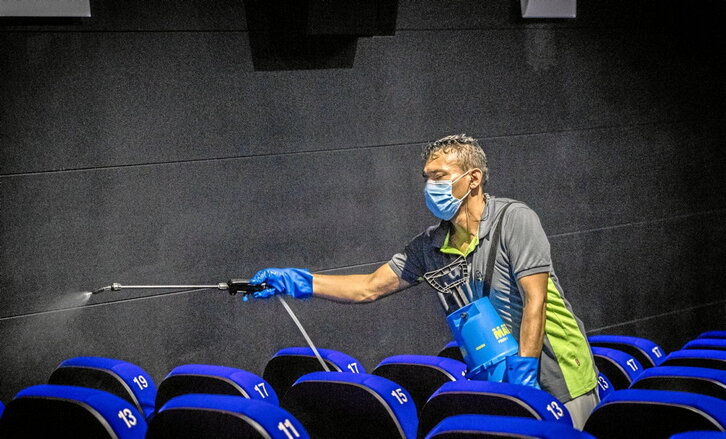 Garbiketako langile bat, zinema aretoa desinfektatzen.