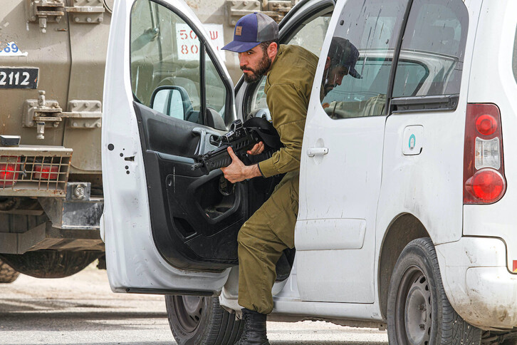 Un soldado israelí se dirige armada hacia un grupo de manifestantes palestinos en Beita, al sur de Nablús, en Cisjordania.