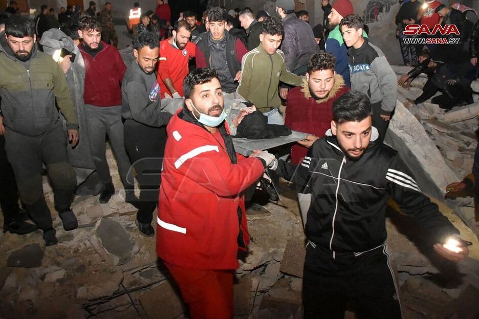 Rescatistas evacuan a una víctima de un edificio de ocho pisos que se derrumbó en Hama, Siria.