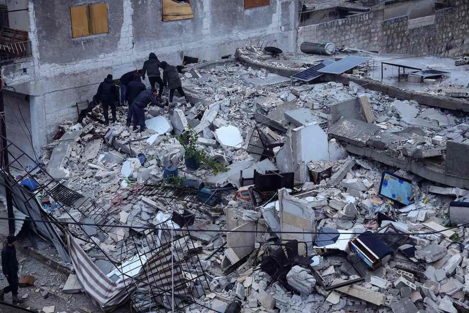 Los residentes buscan víctimas y sobrevivientesen un edificio que se derrumbó en la aldea de Azmarin.