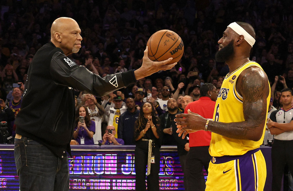 Abdul-Jabbar le tiende el balón a LeBron como reconocimiento por haberse convertido en el máximo anotador de la NBA.