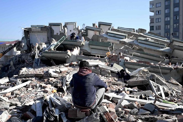 Un hombre sentado sobre los escombros en la ciudad turca de Kahramanmaras. 