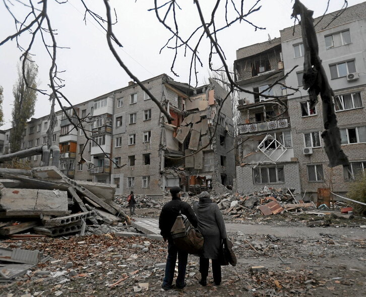 El presidente ruso, Vladimir Putin, en el concierto patriótico del pasado miércoles en Moscú. En la página anterior, bombardeo ruso en Mikolaiev.