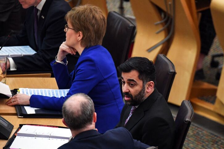 Humza Yousaf sentado junto a Nicola Sturgeon en el Parlamento escocés.