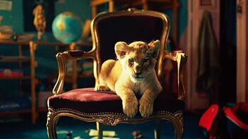 El cachorro de león que protagoniza la película sentado en su trono.