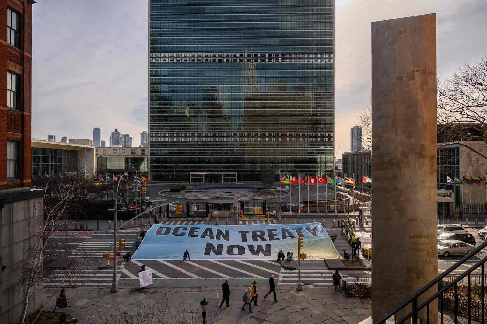 Una pancarta reivindica el tratado de protección de los océanos ante la sede de la ONU en Nueva York. (Ed JONES | AFP)