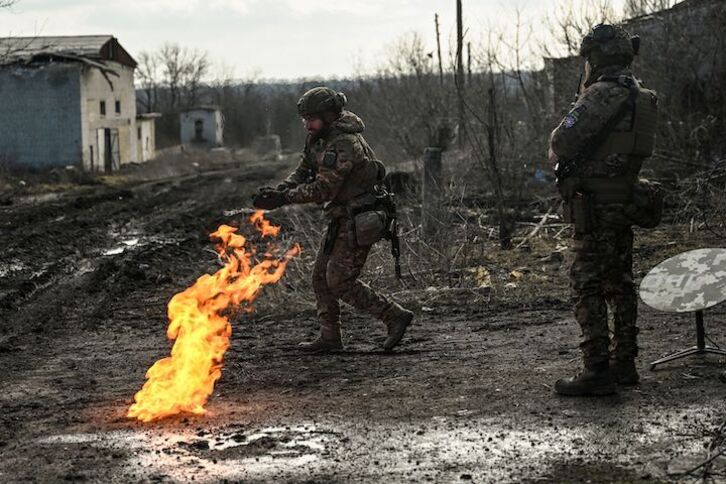Soldados ucranianos tratan de calentarse al fuego en el frente de Bajmut.