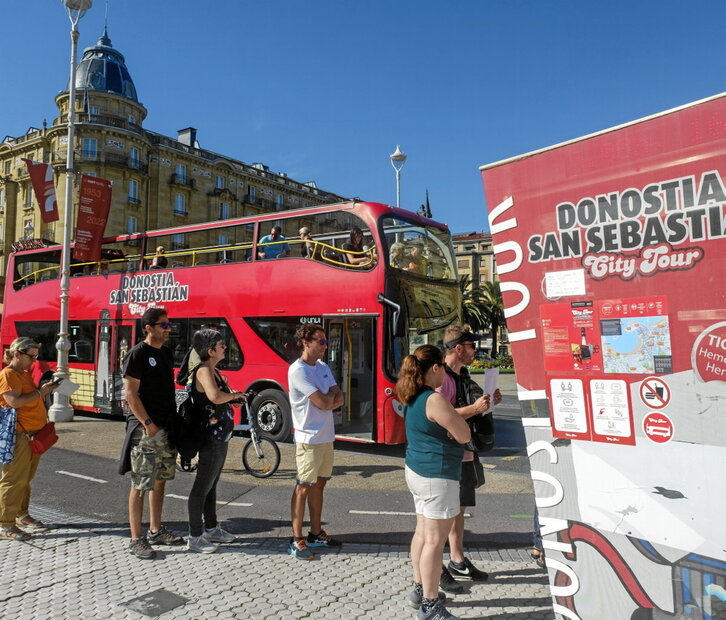 Colas para montar en un autobús turístico en Donostia.