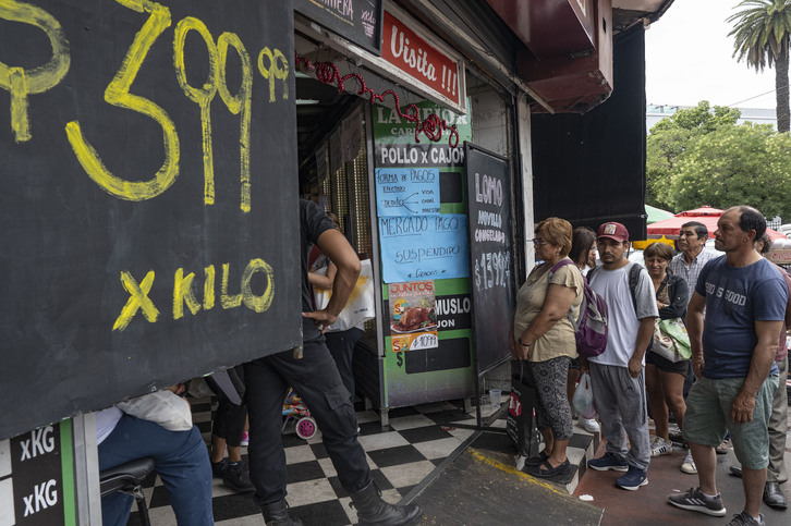 Un grupo de personas hace cola en una carnicería de Buenos Aires. 