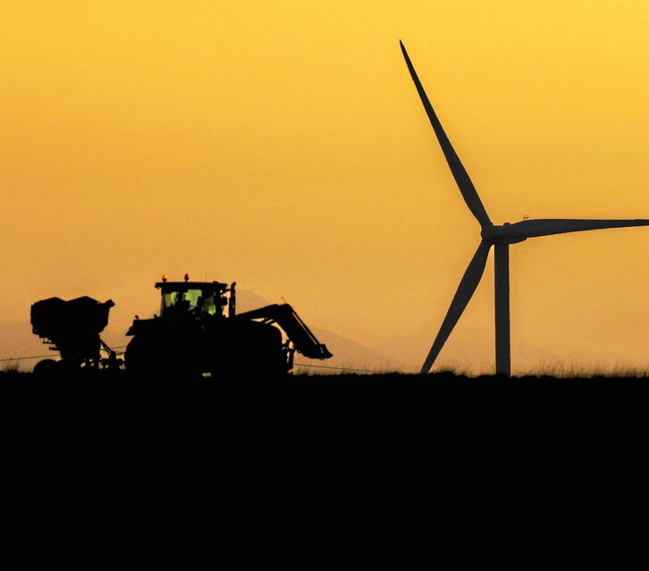Un tractor pasa por delante de un molino de viento en Calmont (Estado francés).