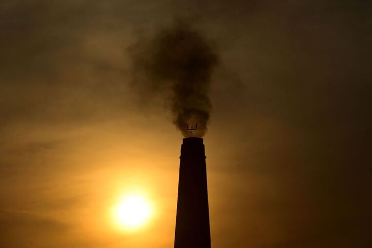 El humo sale de la chimenea de una fábrica de ladrillos en las afueras de Prayagraj (India).
