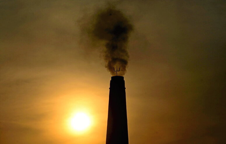 El humo sale de la chimenea de una fábrica de ladrillos en las afueras de Prayagraj (India).