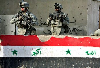 Dos soldados estadounidenses junto a un bloque de hormigón con una bandera iraquí en Bagdad, en enero de 2008.