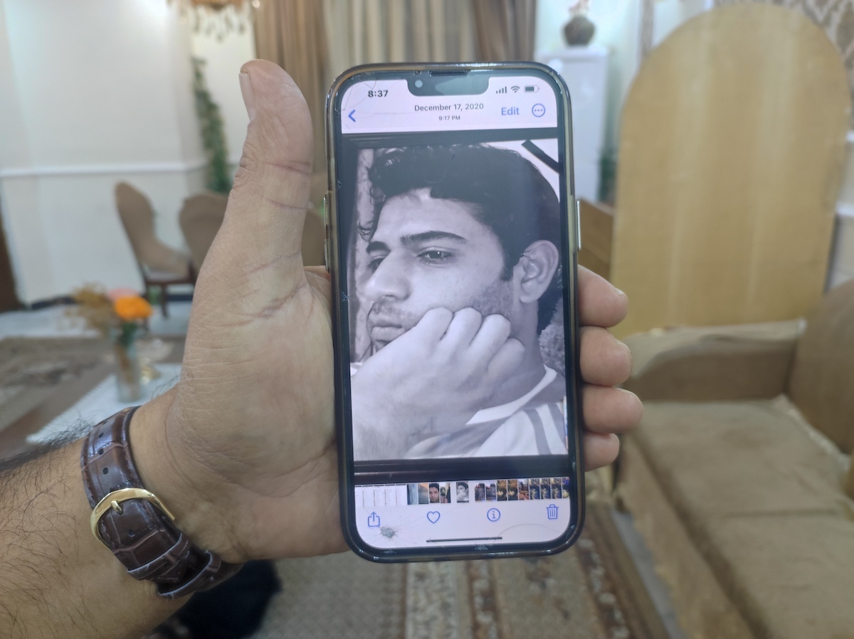 Rahim al-Qabi muestra en el teléfono móvil una foto del hermano al que mataron soldados de Estados Unidos. (David MESEGUER)