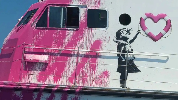 Reinterpretación del mítico mural 'Niña con globo' de Banksy en las paredes del barco humanitario Louise Michel. 