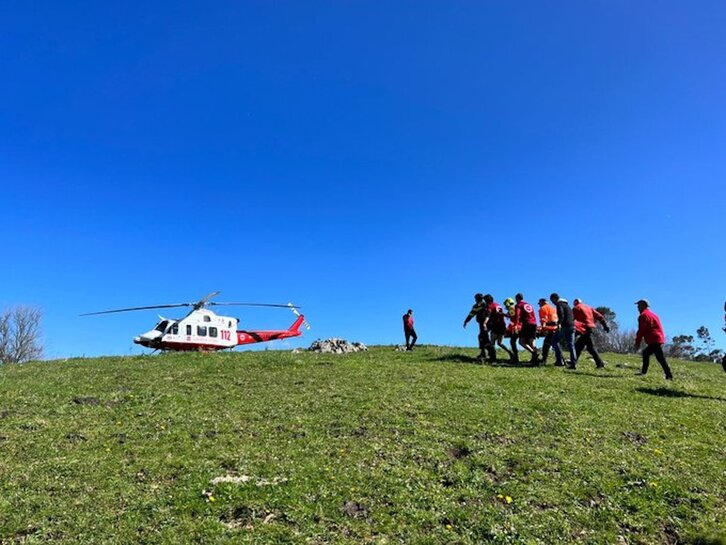 Voluntarios trasladan al herido hasta el helicóptero.