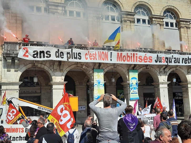 Erretiro adina bi urtez gibelatzeko asmoa salatzeko banderola erraldoia ezarri dute tren langileek Herriko Etxearen balkoian.
