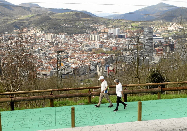 Dos personas pasean en manga corta por el nuevo paseo mirador de Artxanda.