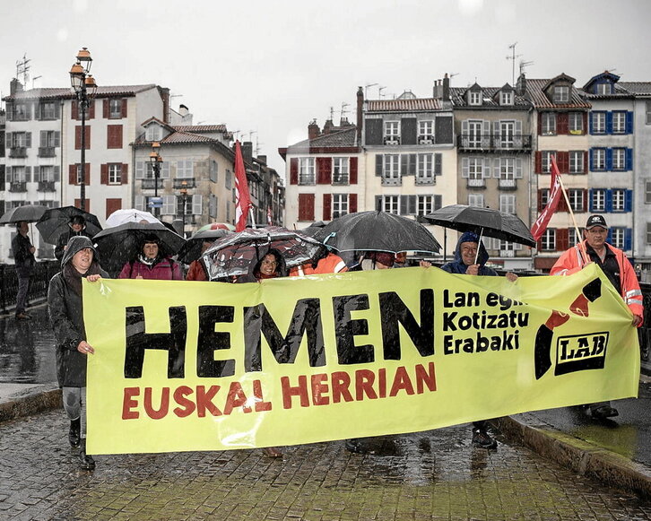 Cortejo del sindicato LAB durante una marcha en Baiona que transcurrió bajo la lluvia.