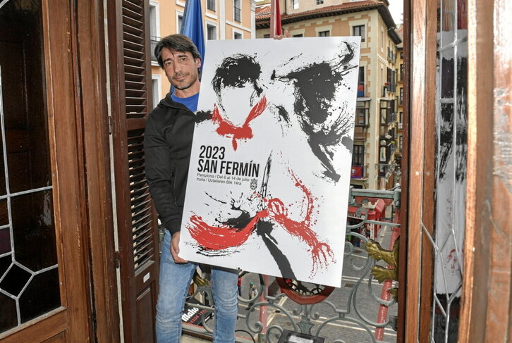 Raúl López posa junto a “Instante”, el cartel de los próximos sanfermines.