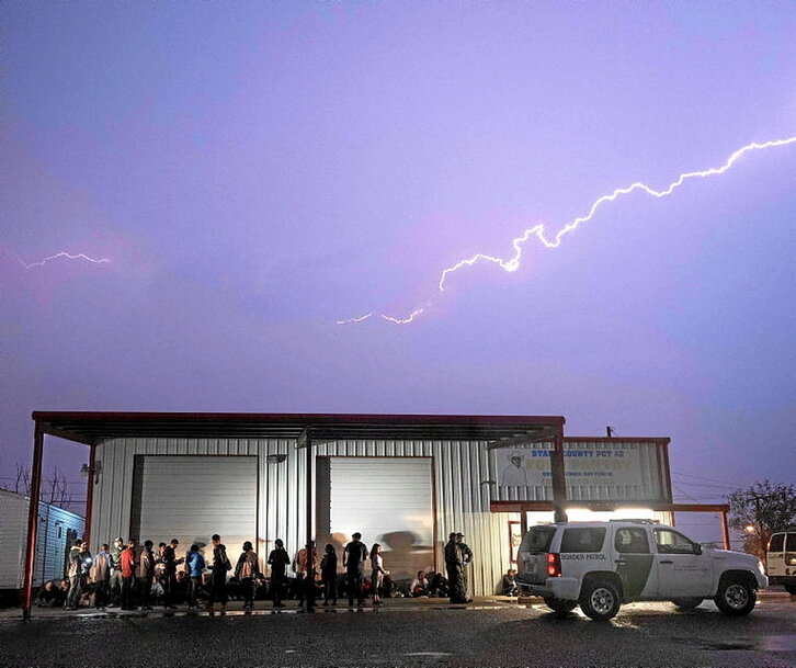 Agentes vigilan a migrantes que se acaban de entregar en Texas.