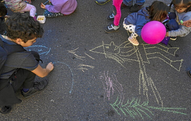 Niños pintan en el patio de un colegio en Bilbo.