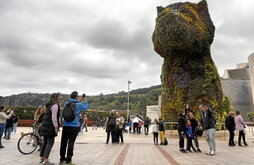 Turistas se retratan ante Puppy, escultura floral de Jeff Koons ubicada en el exterior del Guggenheim en Bilbo.