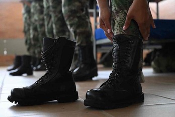 Un soldado colombiano se calza sus botas.