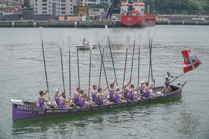San Pedroko arraunlariak, arraunak gora etxeko uretan bandera ospatzen.