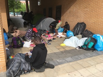 Los vendedores callejeros preparan su mercancía tras descansar en un improvisado campamento.