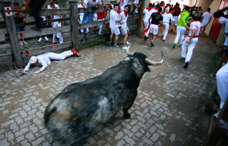 Un corredor busca refugio bajo el vallado al paso del Cebada. Un corredor busca refugio bajo el vallado al paso del Cebada.
