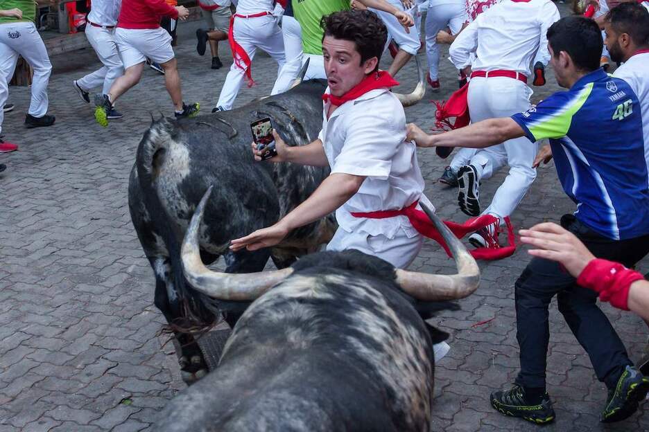 Entre dos toros y móvil en mano. Entre dos toros y móvil en mano.