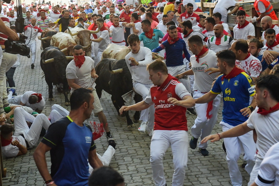 Corredores muy jóvenes ante la cara del toro llegando al coso