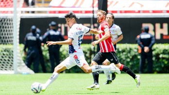 Un jugador del Chivas ensaya el disparo ante la presencia de Muniain.