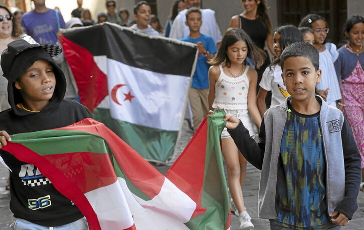 Niños muestran la bandera saharaui y la ikurriña en la fiesta de bienvenida que tuvo lugar ayer en Pasai Donibane.