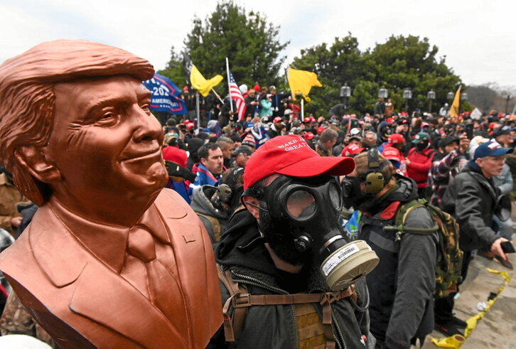 Asaltantes del Capitolio portando un busto de Trump.