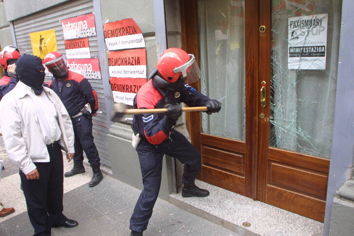 Agentes de la Ertzaintza rompiendo la entrada de la sede de Batasuna en Gasteiz. 