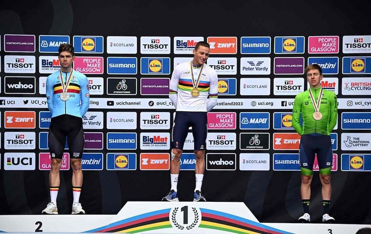 Mathieu Van der Poel, ostadarraren maillotarekin jantzita, Van Aert eta Pogacarren erdian.