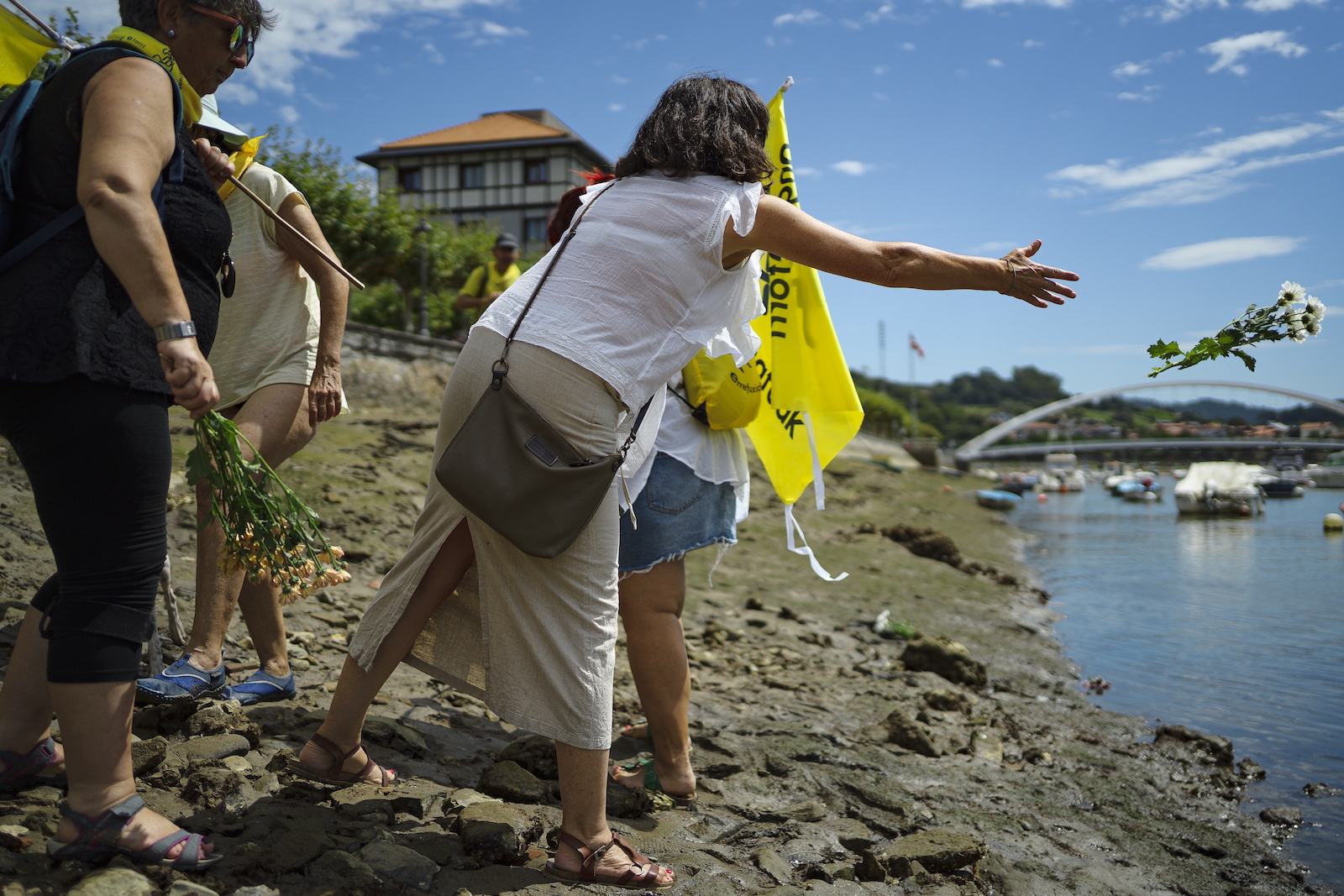 Lanzamiento de flores en recuerdo de las personas fallecidas como consecuencia de las políticas migratorias. (Aritz LOIOLA | FOKU)