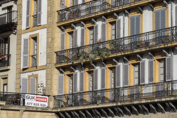 Viviendas y un cartel inmobiliario en la parte vieja de Donostia.
